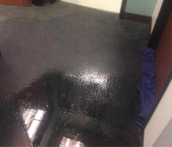 office with grey carpeting covered with water