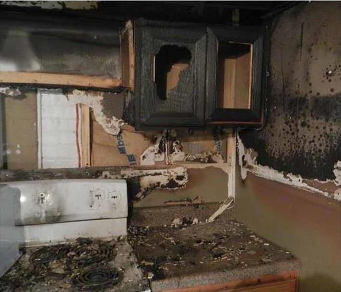 kitchen with cabinets and countertops burned and covered in soot