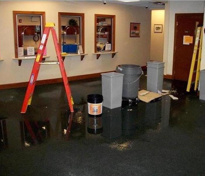 waiting room with wet carpet, trash cans and an orange ladder