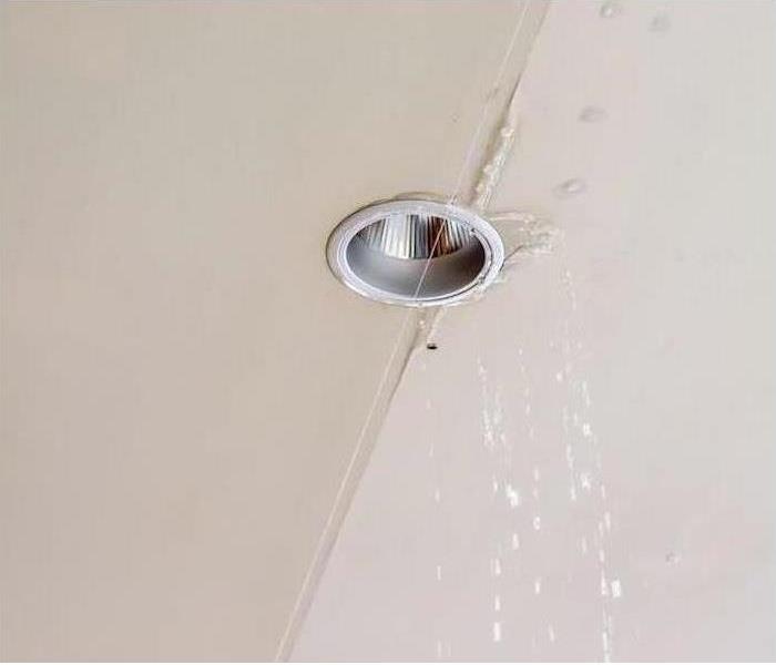 white ceiling with water dripping from the light fixture