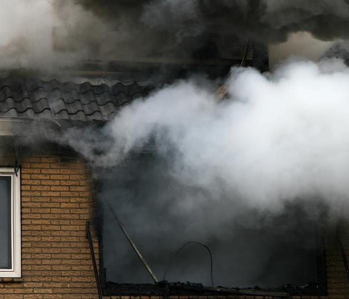smoke billowing out of a home window